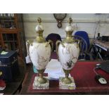 A pair of white marble and giltmetal vases, with domed covers and entwined serpent handles on square