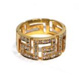 A gold colour metal ring set with diamonds in the form of a Greek key pattern
