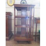 An Edwardian mahogany revolving bookcase, with three tiers on pot castors, 57 cm square, 112cm high