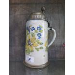 An early 19th century German faience stoneware stein, depicting yellow and blue flowers, the