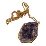 An amethyst piece of quartz, mounted in a gold colour metal neck chain