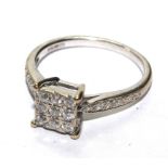 An 18 carat white gold ring, set with nine diamonds in a square table and diamond shoulders