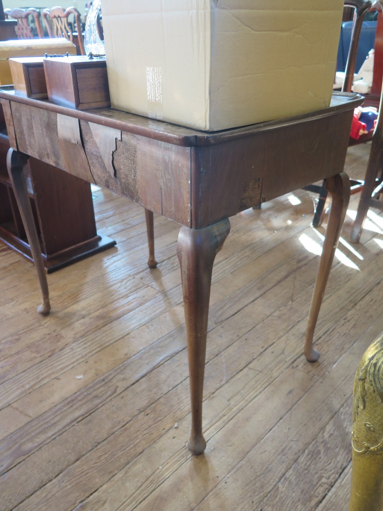 A George II mahogany side table, the dished top with indented corners over a frieze drawer on