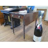 An early 19th century mahogany Pembroke table, the rectangular drop leaves over an ebony strung