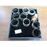A collection of nine silver napkin rings and two silver mounted bottle corks