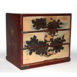 A Japanese lacquer three drawer table top chest of drawers, with floral decoration, 23cm wide, 20.