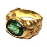 A gold colour ring set with paste stone