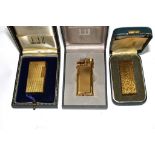 Two gold plated Dunhill Rollagas lighters, and a Dunhill gold plated 'Unique' butane lighter, all
