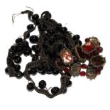 A string of black beads possibly jet and a black bracelet set with plaques