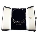 A five strand 18 carat white gold pearl necklace with two colour pearls in original pitted case by