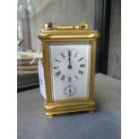 A brass carriage clock, of conventional form with enamel dial and subsidiary alarm dial, the