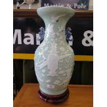 A Chinese celadon vase, with blue and white twin handles, and decorated with vases of flowers on