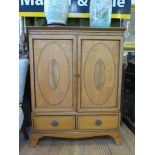 An Edwardian cross-banded satinwood cabinet, the oval inlaid twin doors over a pair of drawers and