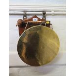 A Middle Eastern engraved brass gong, with a shield shaped wall mount, 31 cm diameter