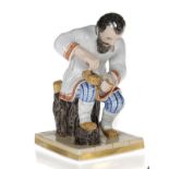 A Porcelain Figurine of a Peasant Making a Bast Shoe