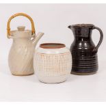 A CREAM GLAZED STUDIO POTTERY JUG with a bamboo handle, indistinctly signed possibly David Leach,