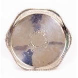 A 20TH CENTURY SILVER TRAY with deep rim and engraved decoration with black cartouche to the