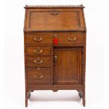 AN EARLY 20TH CENTURY OAK BUREAU pierced gallery top, the fall front opening to reveal pigeon