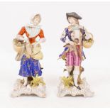 A PAIR OF SITZENDORF PORCELAIN FIGURES of a gallant with a basket of flowers and a girl holding a