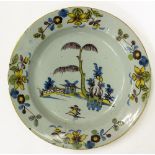 AN ANTIQUE DELFT CHARGER decorated with daffodils, 30cm diameter