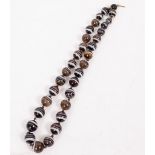 A BEADED BANDED AGATE NECKLACE the largest bead approximately 1.3cm diameter, the necklace 52.5cm