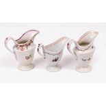 THREE 18TH CENTURY NEWHALL CREAM JUGS with hand painted decoration of flowers and floral