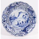 AN 18TH CENTURY CHINESE BLUE AND WHITE DISH the central scene with figures by a lake with