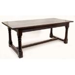 AN 18TH CENTURY STYLE OAK REFECTORY TABLE with turned supports united by a stretcher, the three