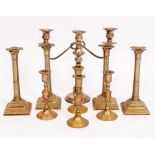 A SET OF FOUR BRASS CANDLESTICKS of column form with stepped square bases 25cm high together with