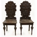 A PAIR OF LATE 19TH CENTURY HALL CHAIRS with carved backs, panelled seats and turned legs, each 47cm