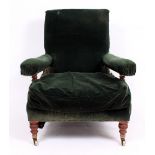 A LATE VICTORIAN / EARLY EDWARDIAN ARMCHAIR upholstered in green fabric, standing on turned feet