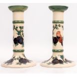 A PAIR OF CONTEMPORARY MOORCROFT POTTERY BIRDS AMONGST FOLIAGE AND FRUIT PATTERNED CANDLESTICKS on a