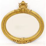 A GILT FRAMED OVAL WALL MIRROR with shell decorated crest, 122cm wide x 120cm high overall