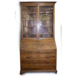 A GEORGIAN MAHOGANY STYLE SECRETAIRE BOOKCASE with glazed astrigal doors above a fall front and four