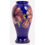 A CONTEMPORARY MOORCROFT POTTERY ANEMONE PATTERNED BALUSTER VASE on blue ground, with signature to