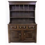 AN 18TH CENTURY OAK DRESSER with a plate rack above three short drawers and two panel doors, 134cm