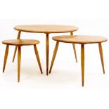 AN ERCOL LIGHT ELM NEST OF THREE TABLES with spindle supports, the largest 65cm wide x 44cm deep x