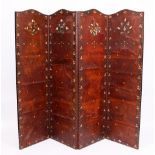 AN EARLY 20TH CENTURY STAINED PINE FOLDING SCREEN OR ROOM PARTITION with painted leather panels