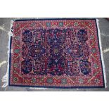 A LATE 20TH CENTURY MIDDLE EASTERN RED AND BLUE GROUND RUG with stylised foliate decoration and a