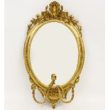 A GILT FRAMED GIRANDOLE MIRROR with decorative laurel swag crest and three candle holders, 56cm wide