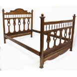 AN ARTS AND CRAFTS OAK 4'6" DOUBLE BED with ball finials, spindle supports and pierced splats,