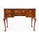 A GEORGIAN STYLE WALNUT VENEERED DRESSING TABLE with various drawers and standing on cabriole legs