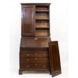 AN 18TH CENTURY OAK BUREAU BOOKCASE the upper section with panelled doors enclosing shelves and with