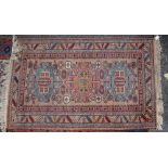 A TURKISH RED, WHITE AND BLUE GROUND RUG with geometric decoration, 87cm x 170cm; a Persian style