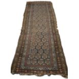 A 20TH CENTURY MIDDLE EASTERN RUG worked in coloured threads with a blue central panel with a