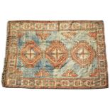 A TURKISH BLUE AND RED GROUND WOOLLEN SMALL CARPET with three central octagonal motifs, a banded