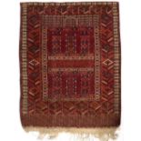 AN ANTIQUE TEKKE TURKMEN RED GROUND RUG with geometric decoration, 137cm x 163cm