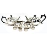 A SILVER BATCHELORS TEAPOT of bulbous shaped form with ebonised trophy handle standing on four bun
