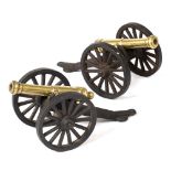 A PAIR OF DESK ORNAMENTS in the form of brass cannon, mounted on cast iron carriages, each 19.5cm