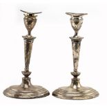 A PAIR OF LOADED SILVER CANDLESTICKS of shaped form on spreading bases, bearing marks for Sheffield,
